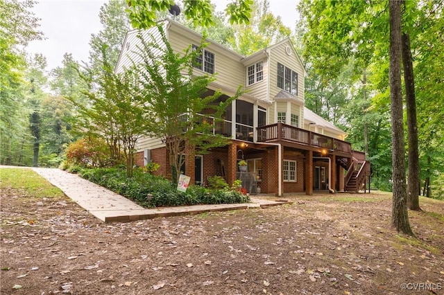 back of house featuring a sunroom and a deck