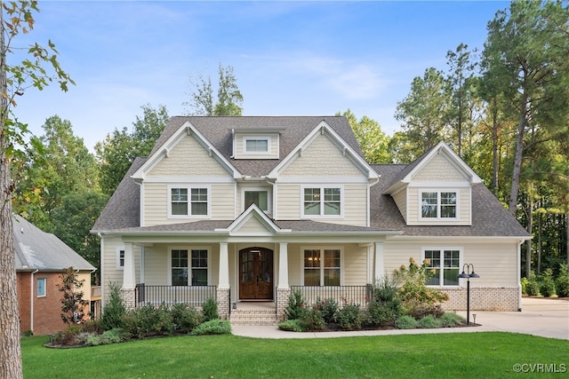 craftsman inspired home featuring a front lawn and covered porch