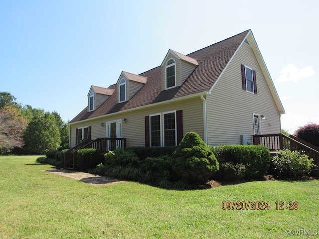 cape cod house featuring a front yard