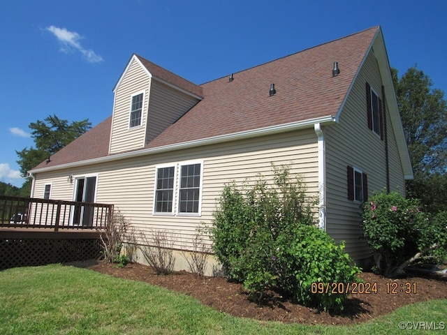 rear view of house featuring a lawn and a deck