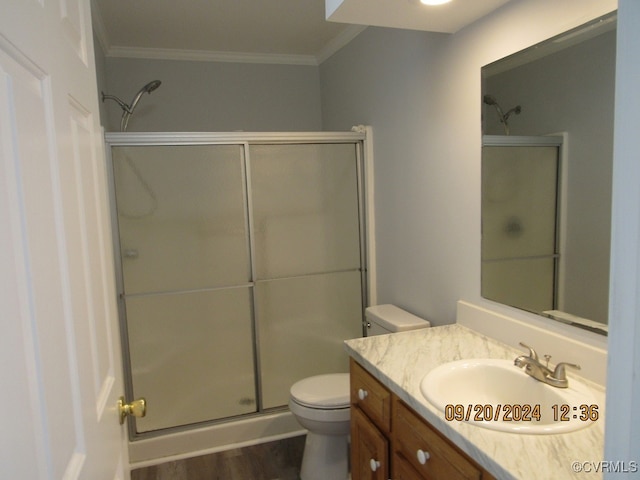 bathroom featuring hardwood / wood-style flooring, an enclosed shower, crown molding, vanity, and toilet