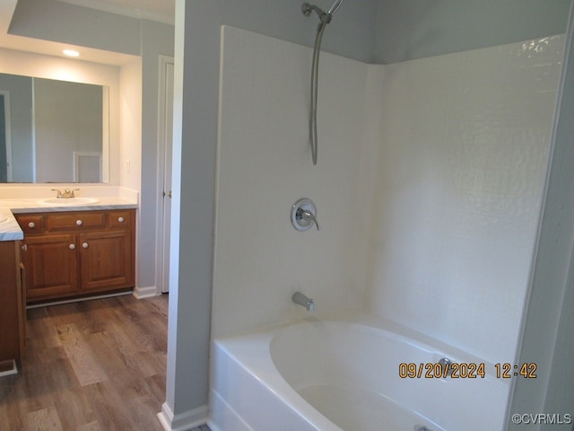 bathroom with tub / shower combination, hardwood / wood-style floors, and vanity