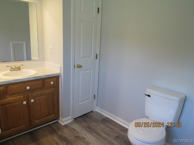 bathroom with vanity, hardwood / wood-style floors, and toilet