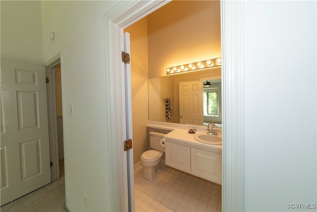 bathroom with tile patterned flooring, vanity, and toilet