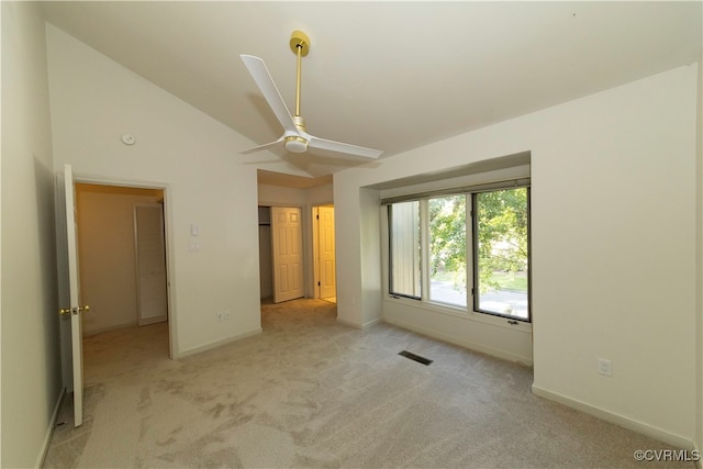 unfurnished bedroom with light colored carpet, vaulted ceiling, and ceiling fan