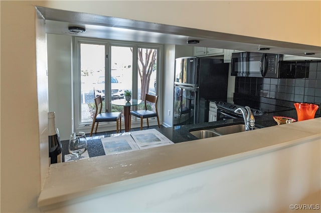 kitchen with sink, backsplash, and black appliances