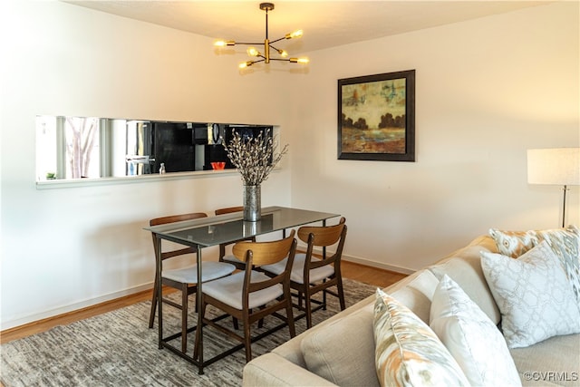 dining room with hardwood / wood-style floors and a notable chandelier