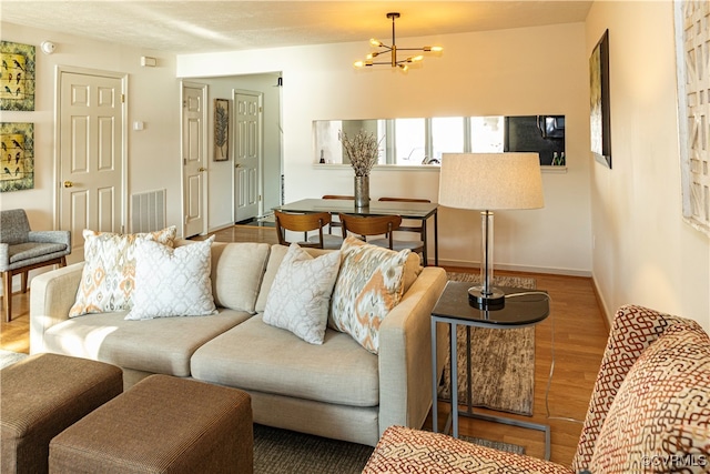 living room featuring wood-type flooring and a chandelier