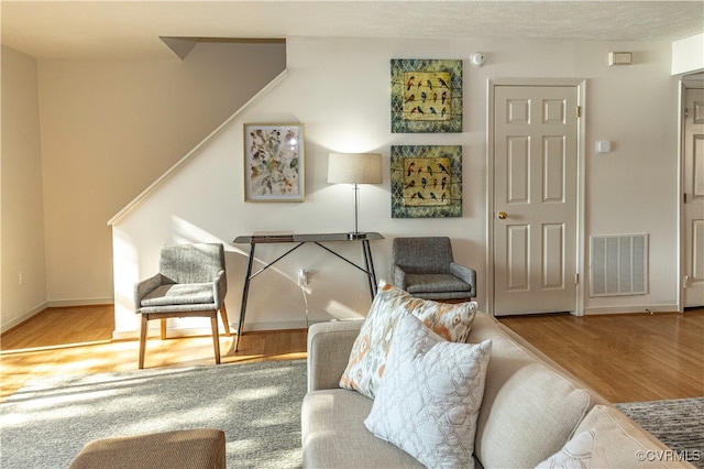 sitting room featuring light hardwood / wood-style floors and a textured ceiling