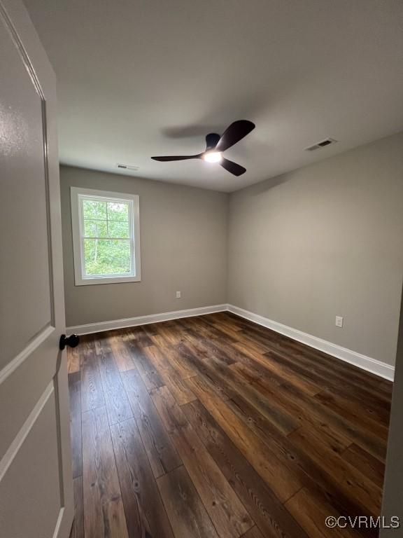 spare room with dark hardwood / wood-style floors and ceiling fan