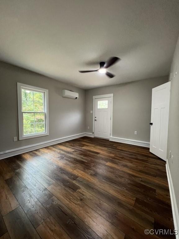 foyer entrance with ceiling fan, dark wood-type flooring, and a wall mounted air conditioner