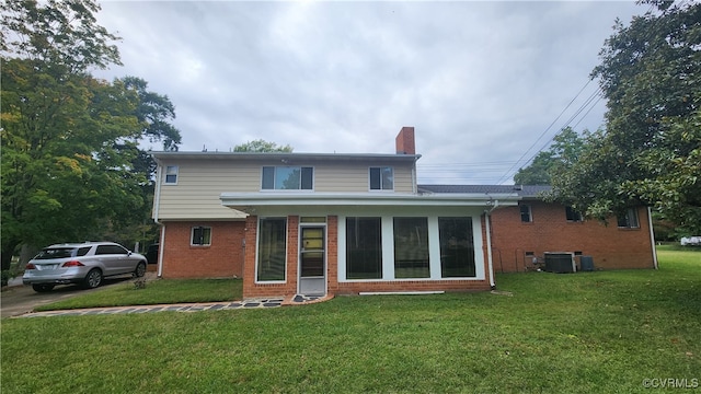 rear view of house with a yard and central AC