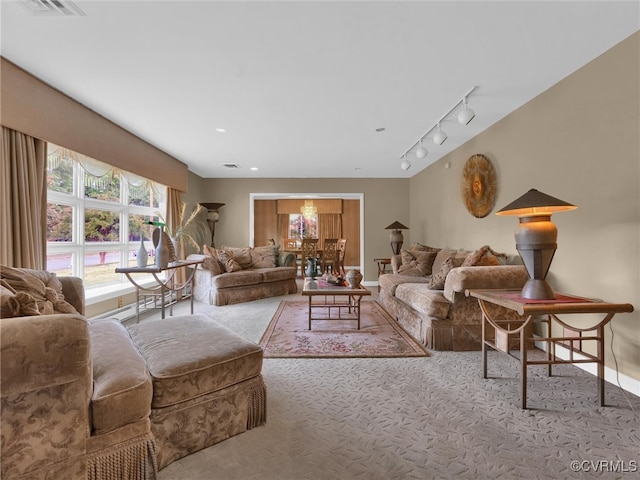 carpeted living room with track lighting