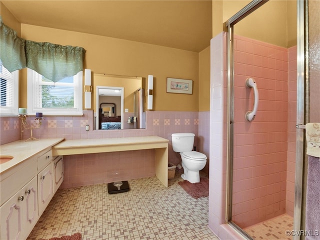 bathroom featuring a shower with door, tile walls, toilet, and vanity