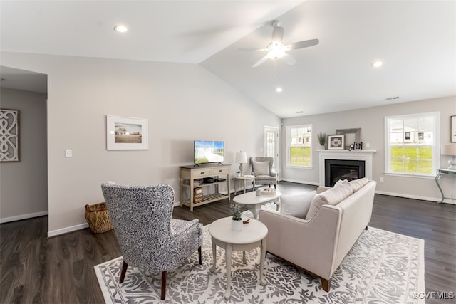 living room featuring ceiling fan, plenty of natural light, and dark wood-type flooring