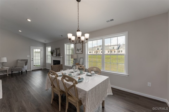 dining space with lofted ceiling, dark hardwood / wood-style floors, and a notable chandelier