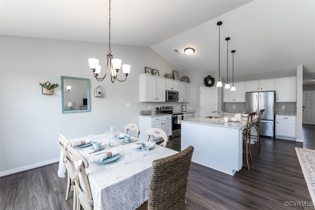 dining room featuring vaulted ceiling, dark hardwood / wood-style flooring, sink, and a notable chandelier