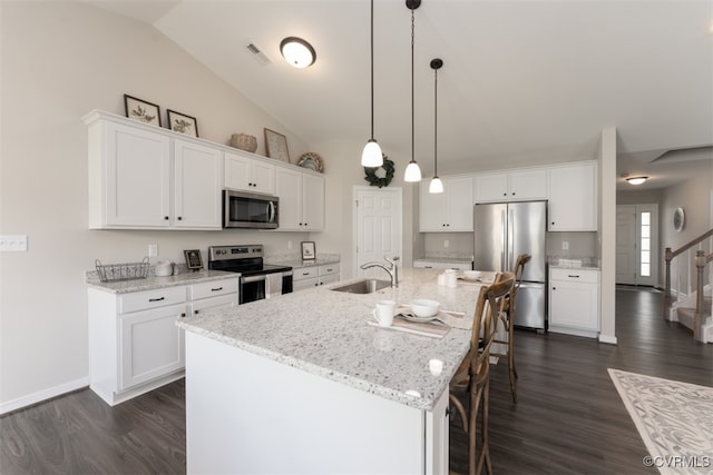 kitchen with white cabinets, an island with sink, appliances with stainless steel finishes, and dark hardwood / wood-style flooring