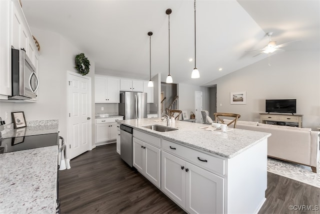 kitchen with white cabinets, an island with sink, appliances with stainless steel finishes, vaulted ceiling, and dark hardwood / wood-style flooring