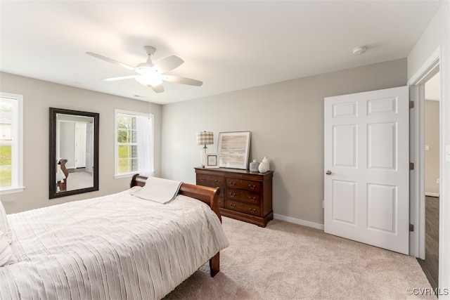 carpeted bedroom with multiple windows and ceiling fan