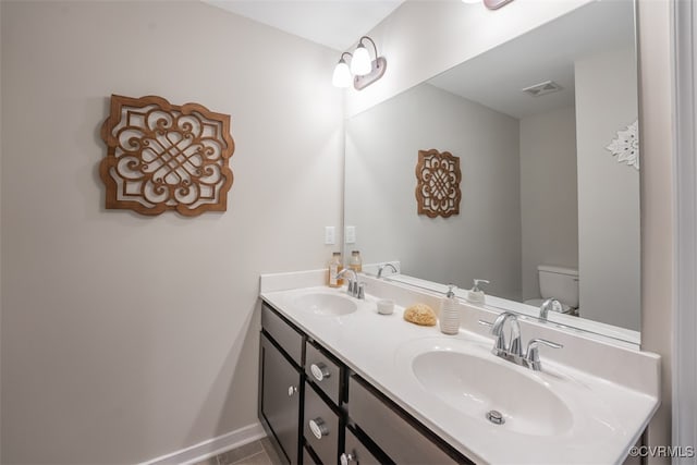 bathroom with tile patterned flooring, vanity, and toilet