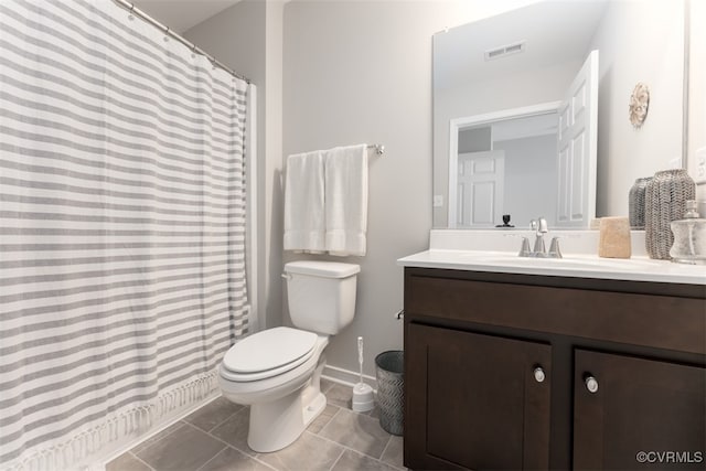 bathroom featuring walk in shower, vanity, tile patterned flooring, and toilet