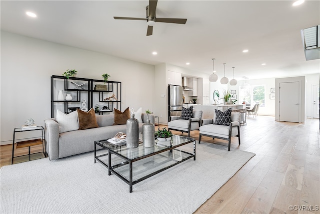 living room featuring light wood-type flooring and ceiling fan