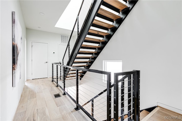 stairway featuring hardwood / wood-style floors and a skylight