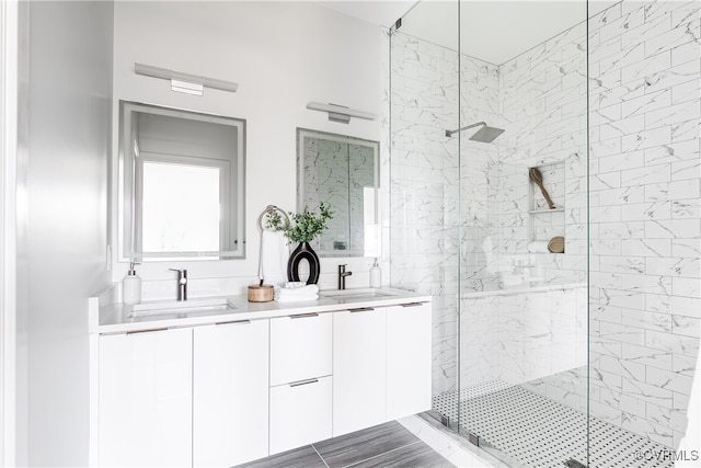 bathroom featuring a tile shower and vanity