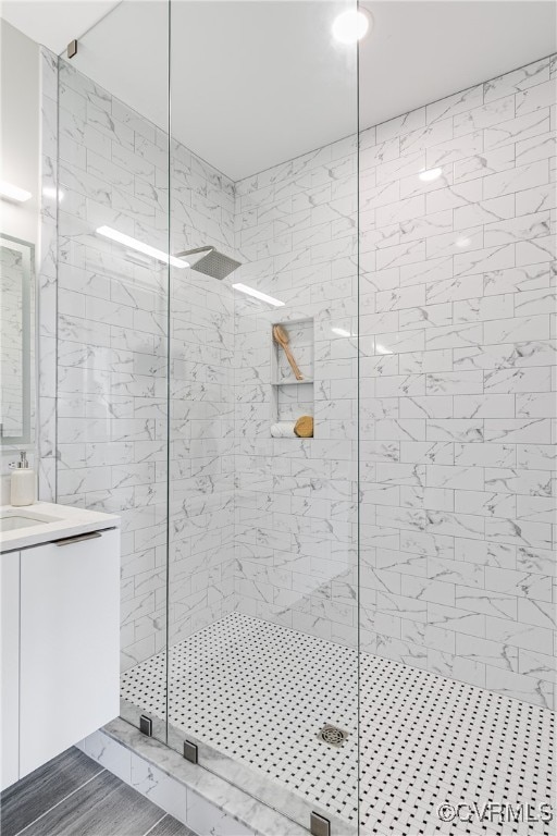 bathroom with vanity and a tile shower