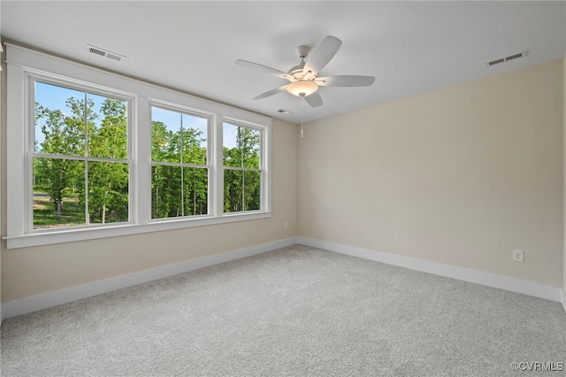 spare room featuring carpet floors, ceiling fan, and plenty of natural light