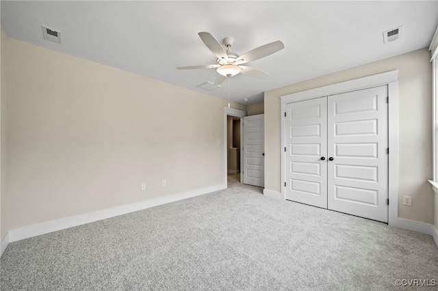 unfurnished bedroom with ceiling fan, a closet, and light carpet