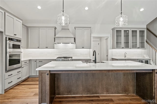 kitchen with an island with sink, stainless steel appliances, and sink