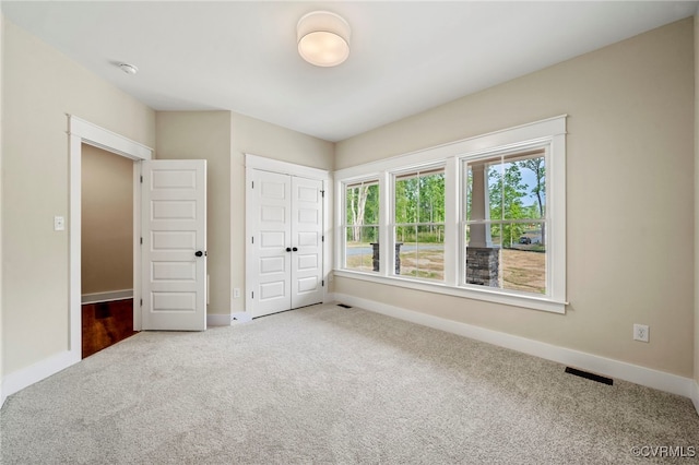 unfurnished bedroom with a closet and carpet floors