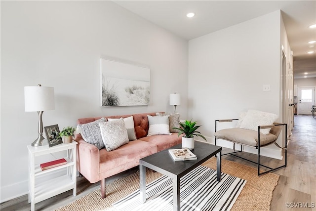 living area with baseboards, light wood-style flooring, and recessed lighting