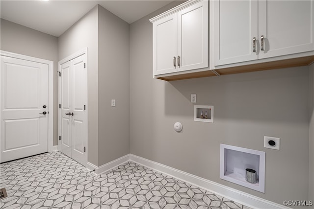 clothes washing area with hookup for a washing machine, gas dryer hookup, electric dryer hookup, and cabinets