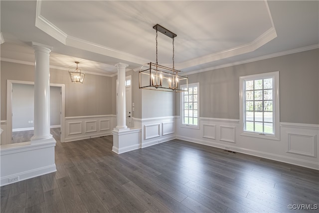 empty room with dark hardwood / wood-style flooring, an inviting chandelier, and ornate columns