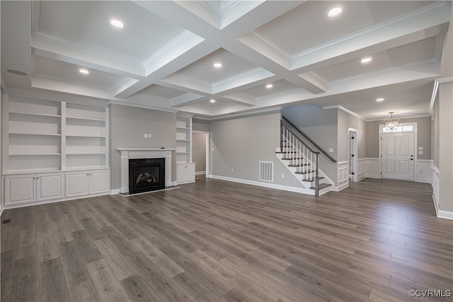 unfurnished living room featuring coffered ceiling, beamed ceiling, crown molding, dark hardwood / wood-style floors, and a notable chandelier