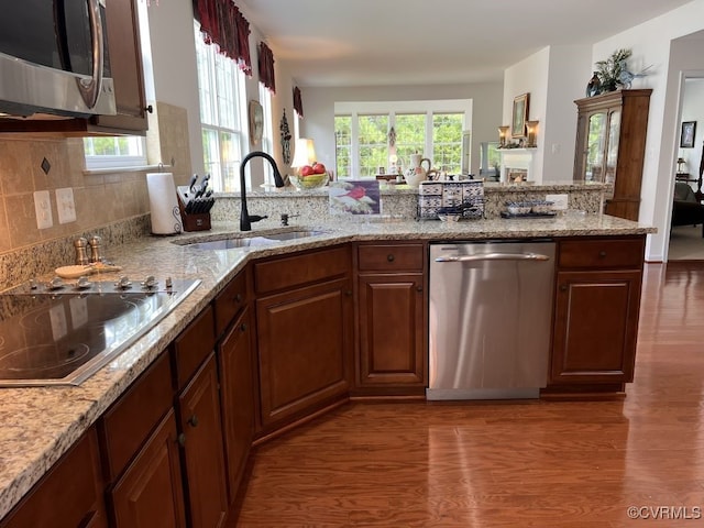 kitchen featuring light stone countertops, sink, stainless steel appliances, and dark hardwood / wood-style flooring