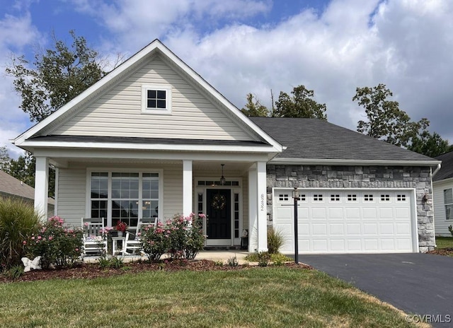 8232 E Lord Botetourt Loop, New Kent, VA 23124 - view of front facade featuring covered porch, aphalt driveway, a front lawn, and an attached garage
