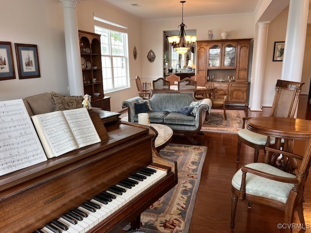 living room featuring a chandelier, decorative columns, and dark hardwood / wood-style flooring