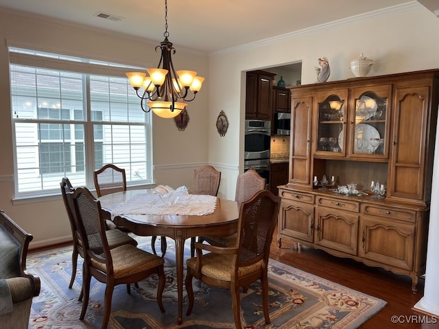 dining area with ornamental molding, dark hardwood / wood-style flooring, and a notable chandelier