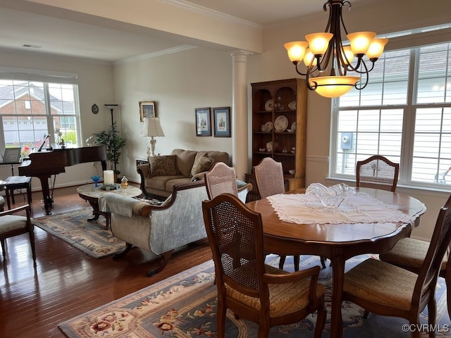 dining area featuring a notable chandelier, ornamental molding, decorative columns, and dark wood-type flooring