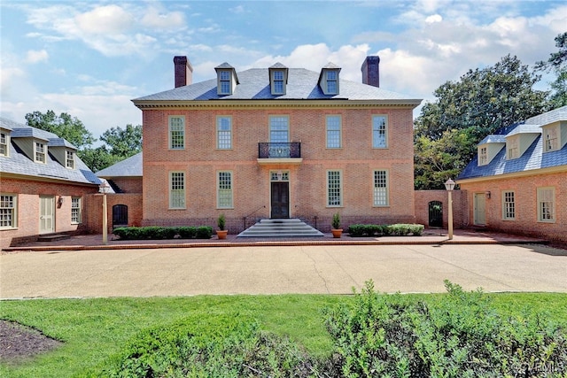 rear view of property featuring a lawn