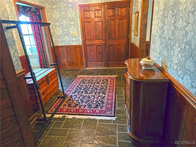 foyer entrance featuring wood walls