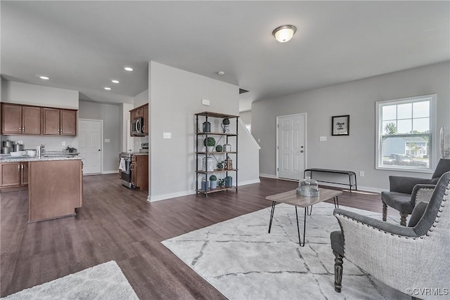 living area with dark wood-style floors, baseboards, and recessed lighting