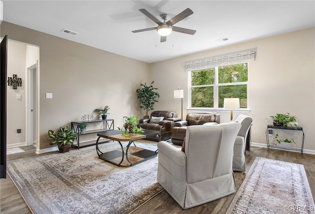 living room featuring ceiling fan and dark hardwood / wood-style flooring