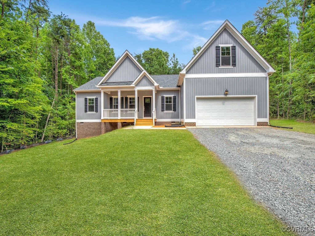 craftsman house with a front yard, a porch, and a garage