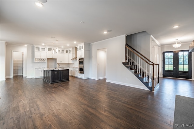 unfurnished living room with crown molding, sink, french doors, and dark hardwood / wood-style flooring