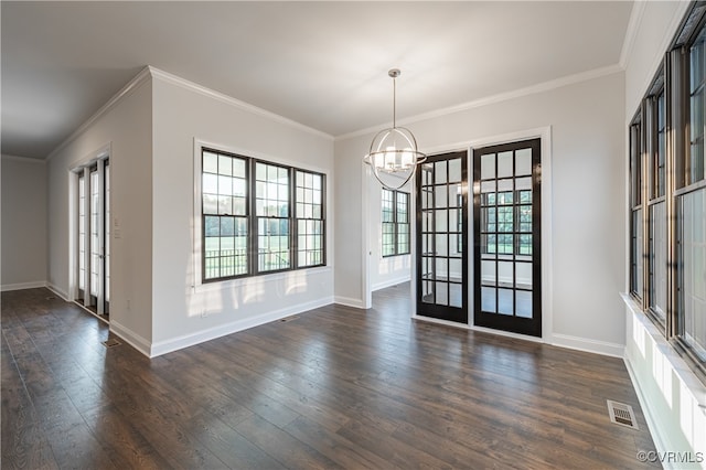 spare room featuring crown molding, dark wood-type flooring, french doors, and a notable chandelier